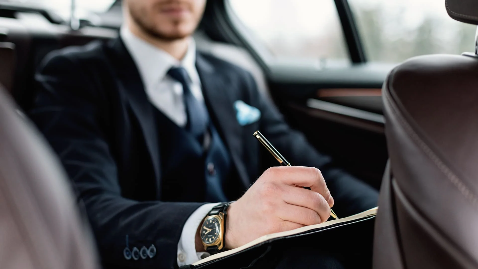 Professional chauffeur opening the door of a luxury vehicle